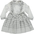 White blouse set with gray plaid skirt with straps and bows on the front