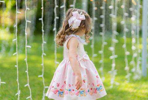 Pink dress with colorful pattern and bows