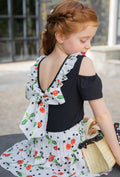 White top with ruffles and patterned black bow